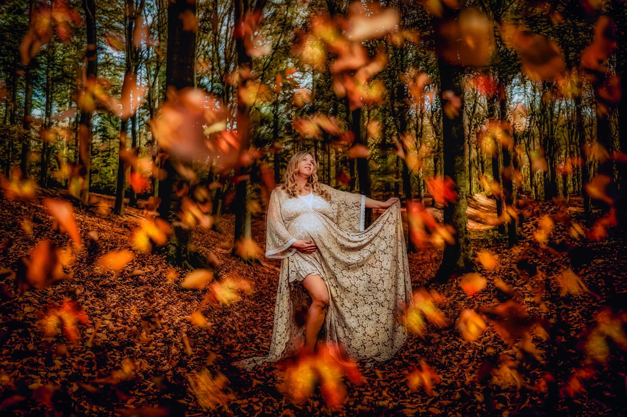 Een stralende aanstaande moeder in een zonovergoten park, liefdevol haar babybuik vasthoudend.